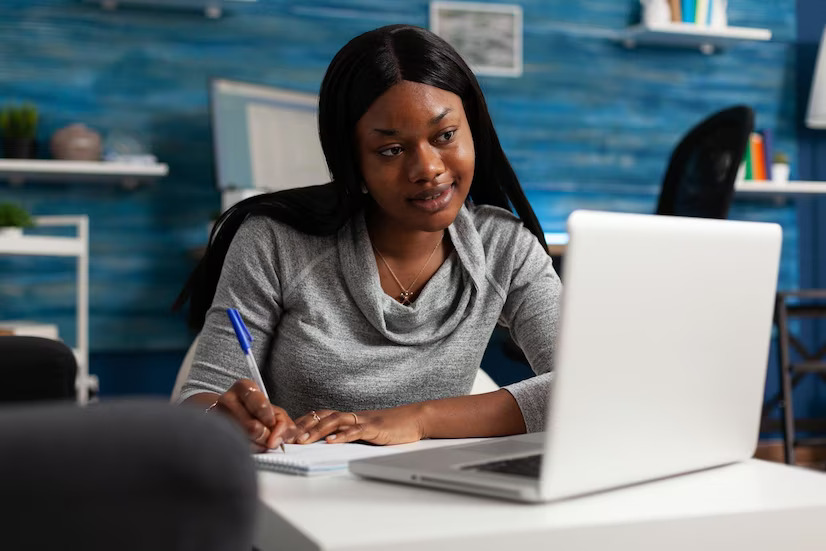 young-person-taking-notes-textbook-paper-with-pen-looking-modern-laptop-woman-writing-information-notebook-files-doing-remote-work-adult-working-from-home-business_482257-27948